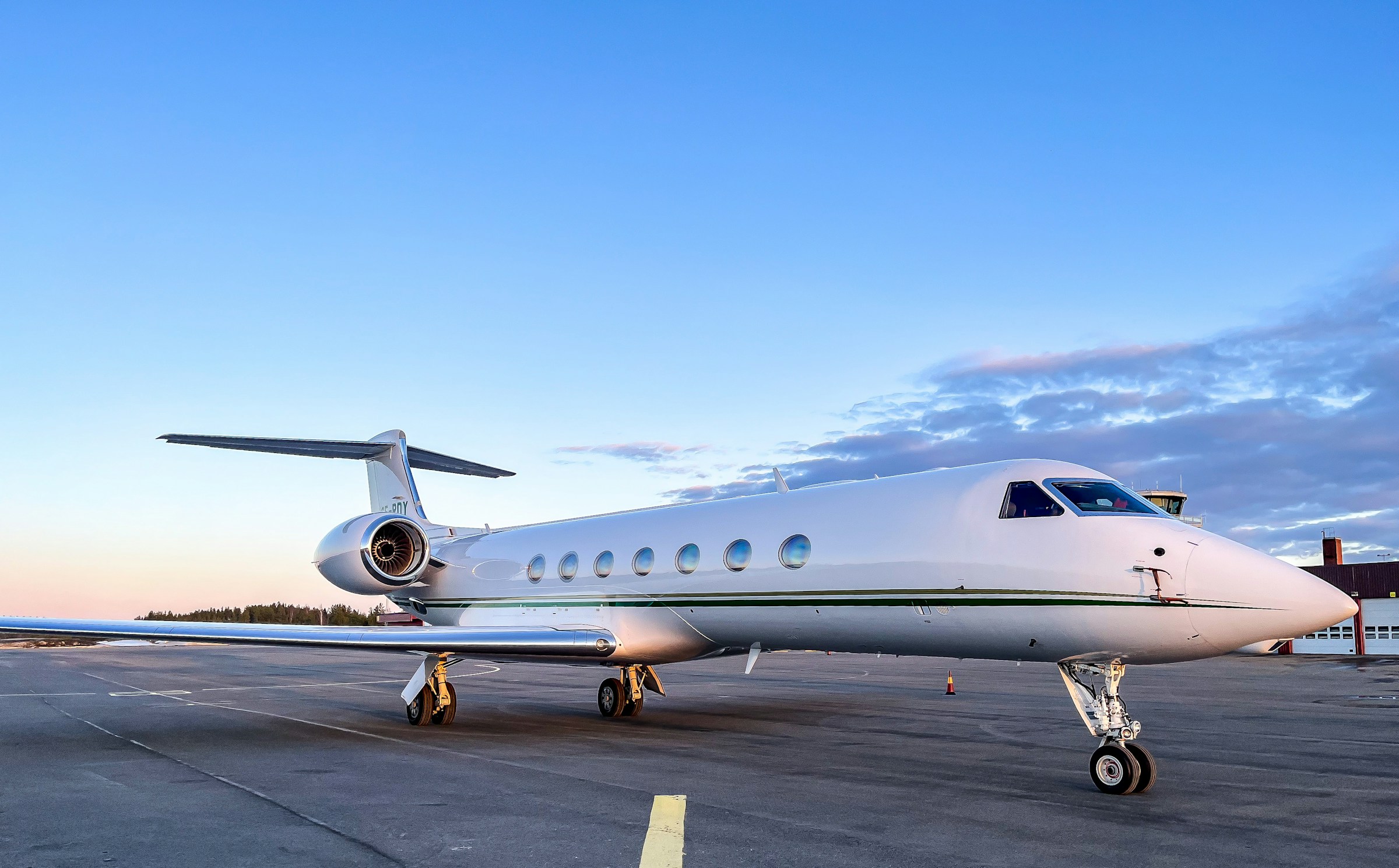 Business jet seen three-quarter on the apron at dusk